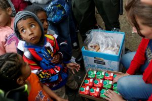 Venezuelan migrant children line up to receive food at a makeshift camp near the transport terminal in Bogota, Colombia